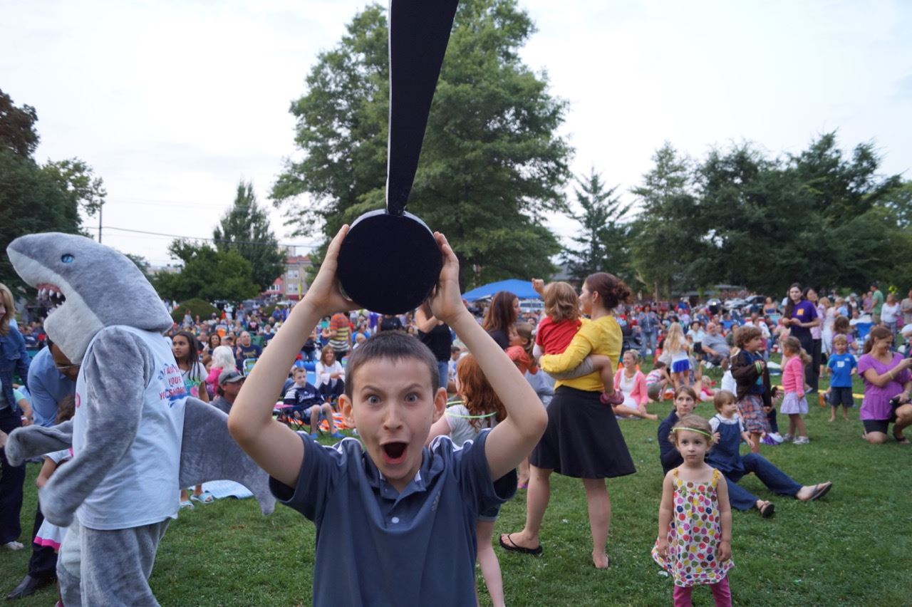 Little boy holds the Share the Fun exclamation point.